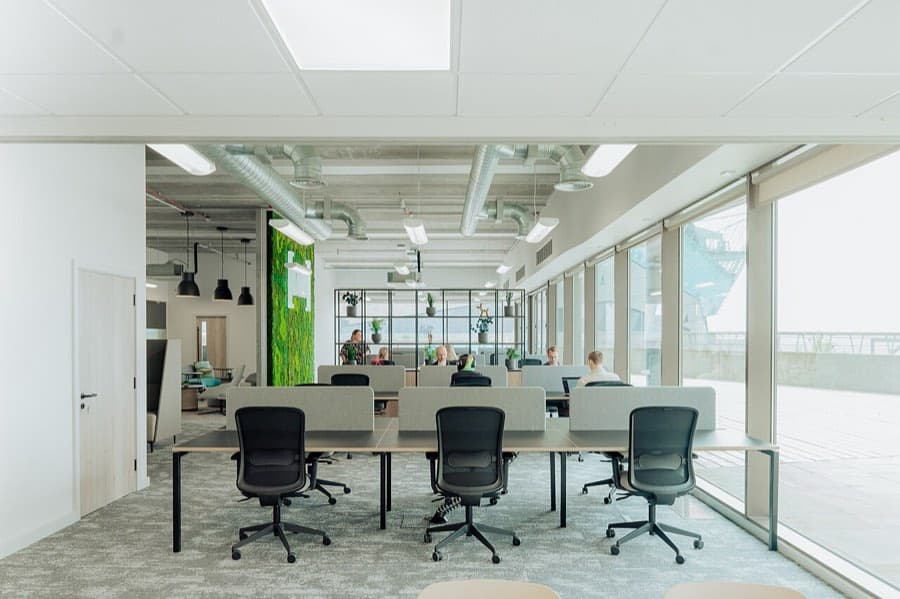 Espace de travail lumineux d’un cabinet, bureaux partagés face aux baies vitrées